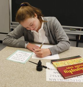 An Oak Knoll student practices calligraphy during Scribes club