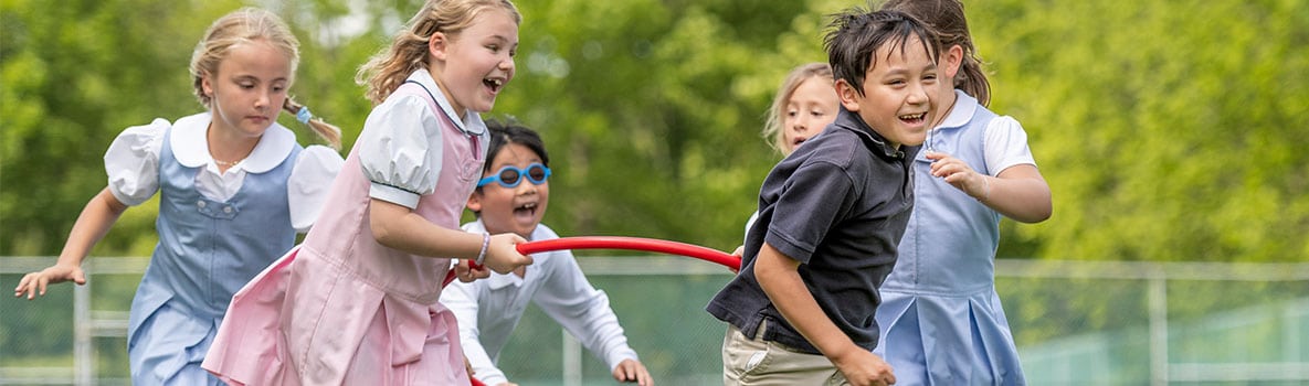 Lower School students running on the turf field together