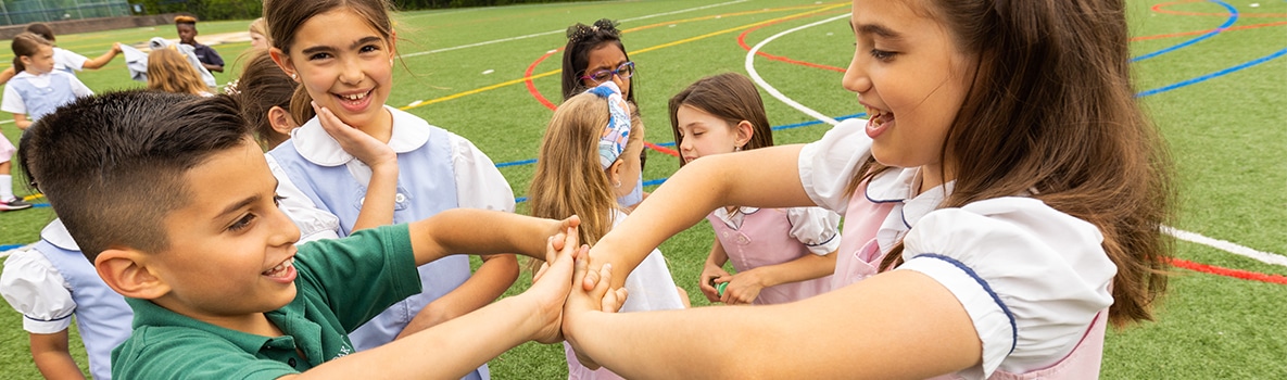 Students play hand clapping game during recess.