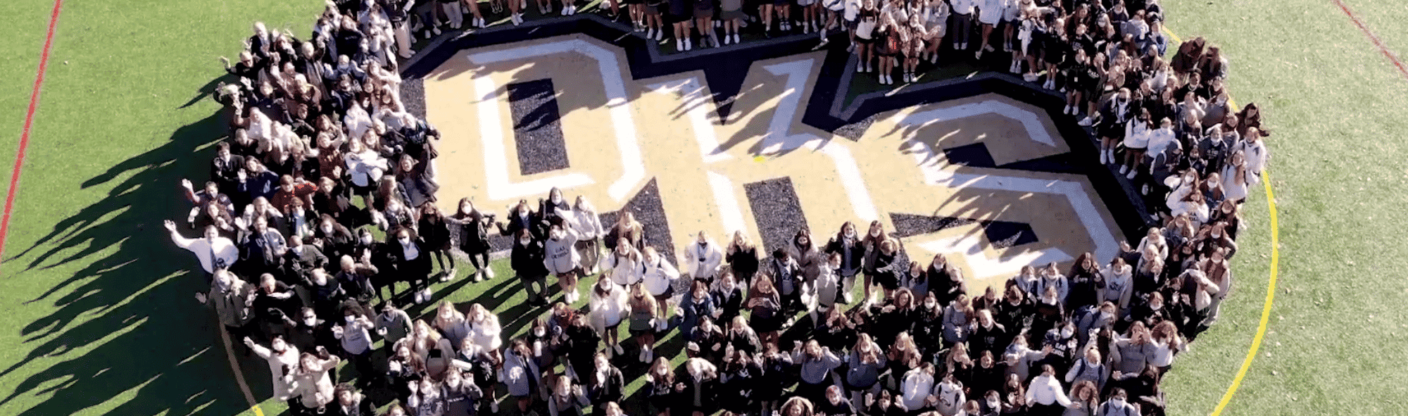 oak knoll school students surrounding logo on field